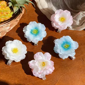 Detailed top view of sweet fabric flower hair clips in pink, white, and blue.