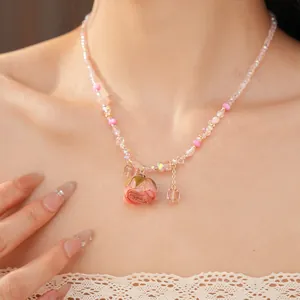Close-up of beaded necklace with a preserved rose pendant on a woman's neck