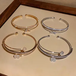 Elegante bracciale rigido aperto a doppio strato con zirconi e fiocco in oro e argento