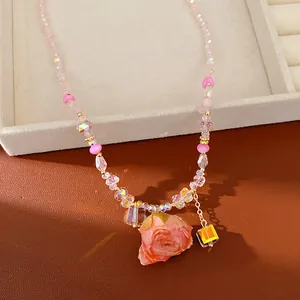 Detailed macro view of preserved rose pendant with sparkling crystals and glass beads
