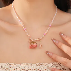 Close-up view of a pink glass bead necklace featuring a romantic dried rose pendant.
