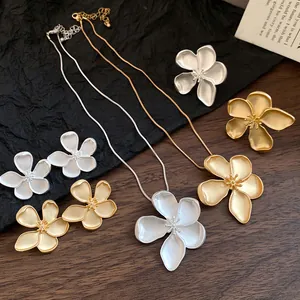 Exquisite detail of vintage matte gold and silver flower necklace and earrings set