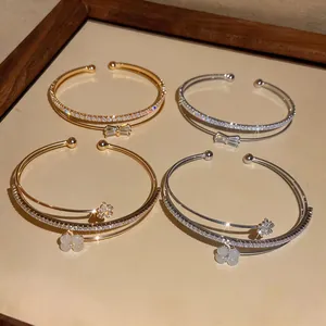 Primo piano di eleganti bracciali a doppio strato in oro e argento con cristalli.