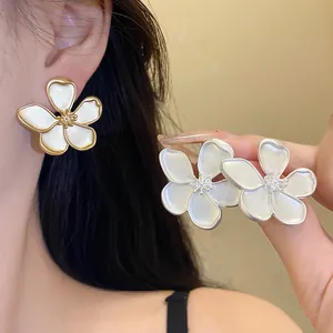 Detailed close-up of elegant vintage-style flower stud earrings on an Asian model.
