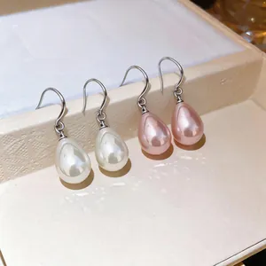 Detailed macro shot of elegant French style waterdrop pearl hook earrings in white and pink