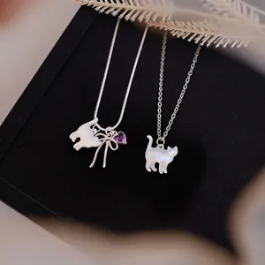 Elegant shell cat pendant necklaces with silver chains presented on a black display box.