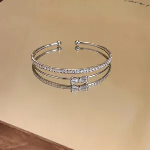 Dettaglio del bracciale a doppio strato con fiocco in zircone e pietre pavé.