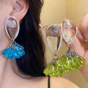 Detailed view of fashionable resin teardrop tassel earrings with silver needles.