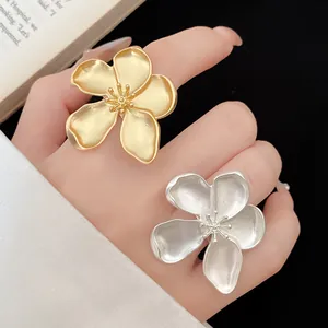 Detailed macro shot of elegant vintage matte gold and silver flower-shaped rings worn on fingers