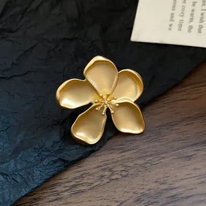 Macro detail of a vintage matte gold flower jewelry piece with an intricate stamen