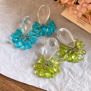 Macro view of elegant teardrop resin earrings in aqua blue and lime green finishes