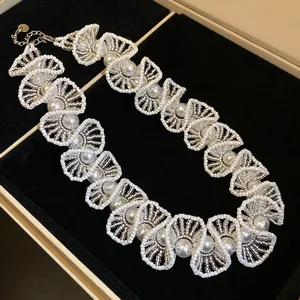 Nahaufnahme einer handgefertigten Vintage-Perlenkette mit weißen Glasperlen und Akzenten.