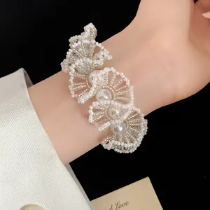 Detailansicht eines handgefertigten weißen Perlenarmbands im französischen Retro-Stil