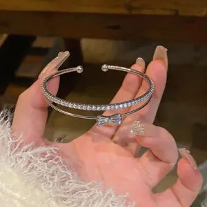 Primo piano di un bracciale rigido a doppio strato con un fiocco di zirconi scintillanti.