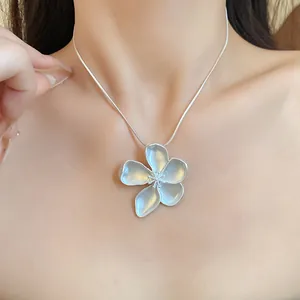Close-up of elegant vintage matte silver flower pendant necklace on a snake chain