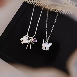 Close-up detail of shell cat pendants with purple heart gem and elegant silver chains