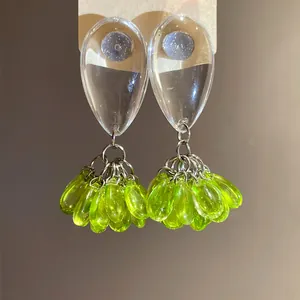 Detailed view of fashionable lime green resin drop tassel earrings with clear studs