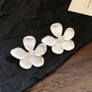 Close-up of vintage matte silver flower stud earrings with elegant texture