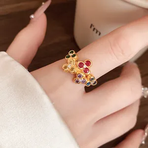 Close-up of vintage multi-color zircon flower ring on finger