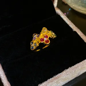 Detailed macro view of a vintage gold ring featuring vibrant colorful zircon flower clusters