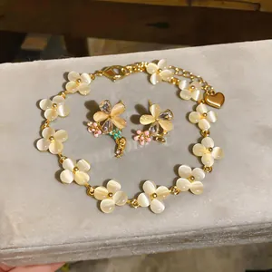 Vue détaillée de l'élégant ensemble bracelet fleur et boucles d'oreilles clous