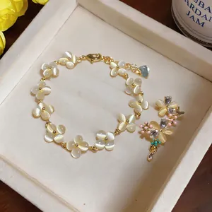 Détail d'un bracelet fleurs en œil de chat et boucles d'oreilles sur un plateau