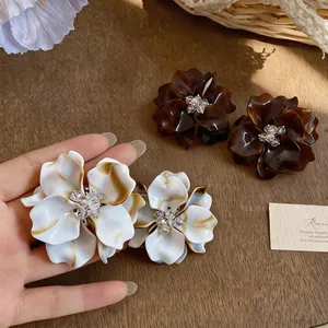 Detailed view of handmade floral stud earrings with resin petals and glass bead centers.