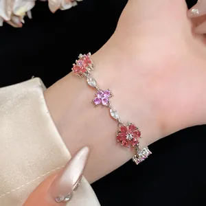 Close-up van een elegante bloemenarmband met roze en paarse zirkonia om een pols