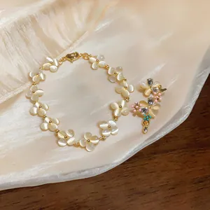 Détail de l'ensemble bijoux français avec fleurs en œil-de-chat et papillons.