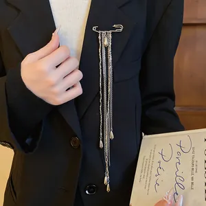 Close-up view of a vintage silver-tone water drop tassel brooch pinned on a black blazer.