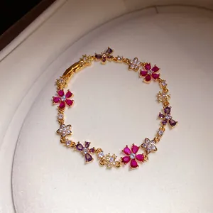 Detail van een elegante zirkonia bloemenarmband met gekleurde edelstenen goud.