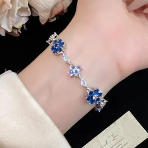 Detailopname van blauwe zirkoon bloemenarmband om de pols met elegant tuinontwerp