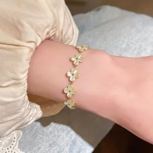 Gros plan élégant d'un bracelet fleur doré avec pierres œil de chat sur un poignet