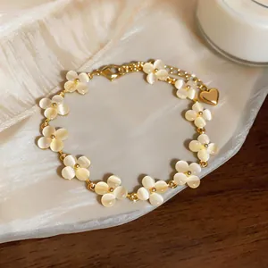 Élégant bracelet en chaîne dorée orné de fleurs en pierre d'œil de chat et d'un pendentif cœur
