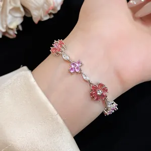 Dichtbij van elegante bloem zirkoon armband met roze en paarse stenen om pols