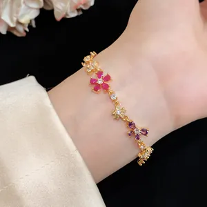 Detail van een goudkleurige armband mit kleurrijke zirkonia bloemen in Monet-stijl