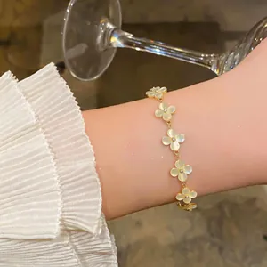 Élégant bracelet en or avec fleurs en œil-de-chat porté au poignet avec manche plissée