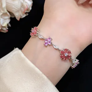 Gedetailleerd overzicht van een zilverkleurige armband met roze en paarse zirkoonbloemen