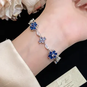 Gedetailleerde macro-opname van een elegante zilveren armband met blauwe zirkoon bloemen