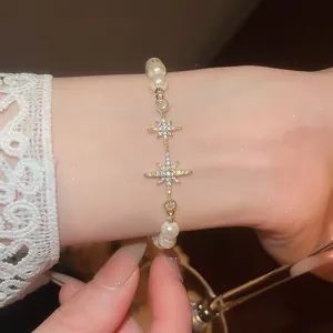 Elegant close-up of 18k gold-plated pearl bracelet with sparkling zircon star motifs