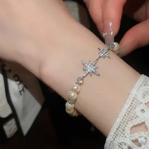 Detailed macro shot of an elegant pearl bracelet featuring sparkling zircon star charms