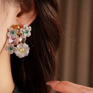 Close-up of vintage-style floral stud earrings with multi-colored crystals and zircons