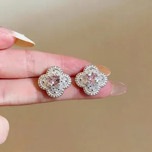 Eleganti orecchini a lobo in argento a forma di fiore con zirconi rosa brillanti sulle dita.