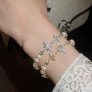 Close-up of elegant 18k gold plated star and pearl bracelets with sparkling zircons