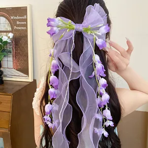Vista posteriore di una clip per capelli a fiocco in organza viola con fiori di mughetto