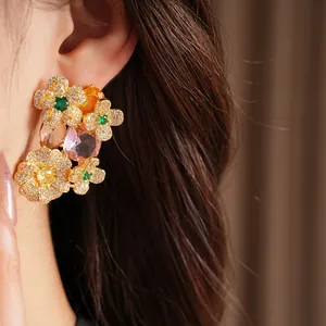 Close-up of vintage floral stud earrings featuring colorful zircons and oval gemstones
