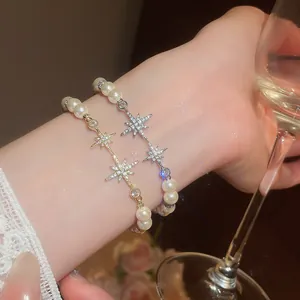 Close-up detail of elegant 18k gold plated pearl bracelets with sparkling zircon star charms