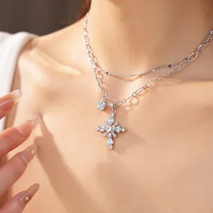 Macro detail view of double-layer chain necklace featuring a blue zircon cross.