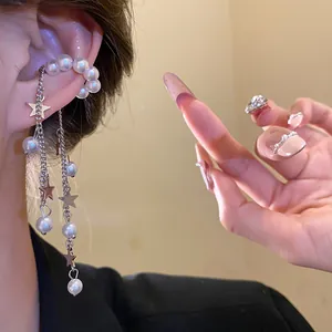Detail view of stylish pearl beaded tassel ear cuff with star charms on metal chains.