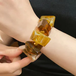 Detailed macro view of a vintage amber acrylic chunky bracelet on an elegant wrist.